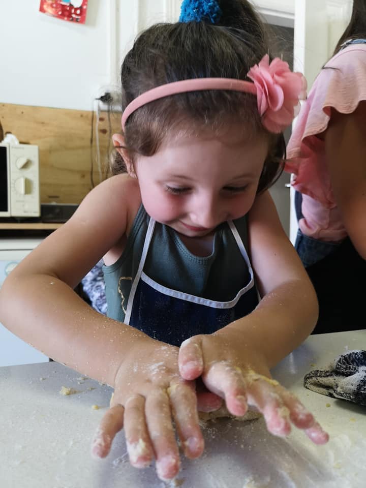 A child concentrating on decorating their bake