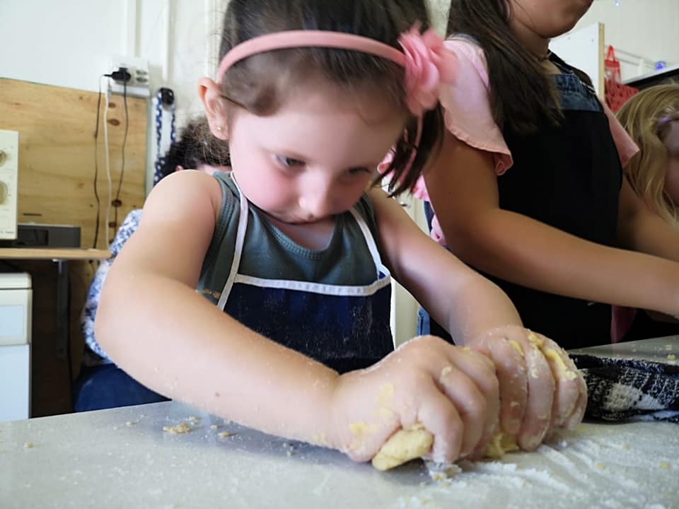 A young chef carefully decorating at a Pikanini Chefs class